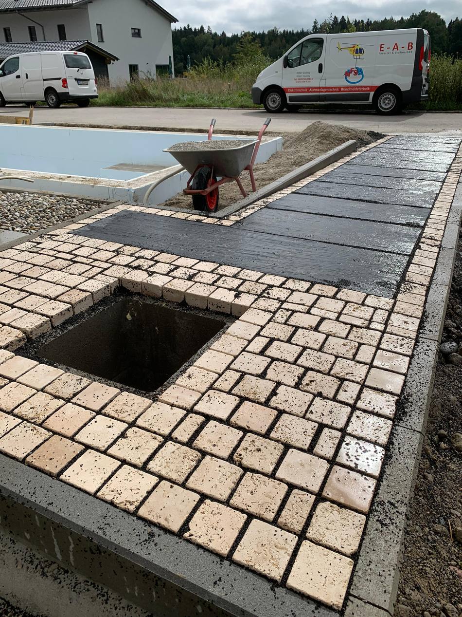 Poolumrandung aus Travertin-Natursteinplatten an einem Neubau
